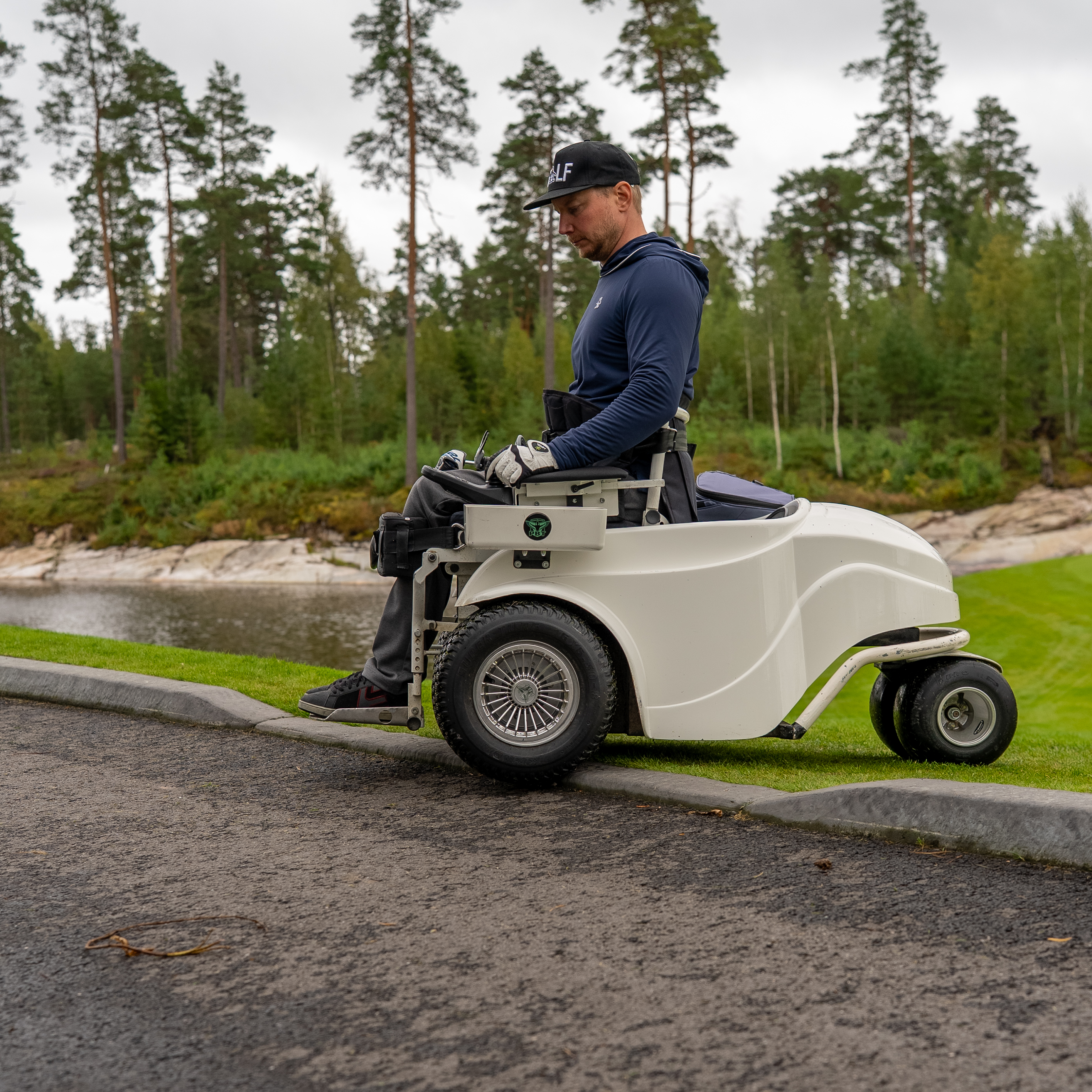 Kuvassa henkilö menossa paragolferilla madalletun reunakivetyksen yli. 